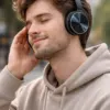 Auriculares Stima 220 Super Bass en color negro con diseño metálico brillante, presentados sobre fondo oscuro elegante que resalta el acabado premium y los detalles circulares de los auriculares